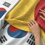 Hands examining colorful Korean fabric samples with traditional patterns, symbolizing the process of...