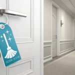 Hotel room door with a 'please clean' symbolic door hanger, hinting at a tidy room and a Korean city...