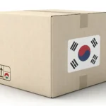 Illustration of a cardboard package with a South Korean flag sticker next to an airplane and globe,...
