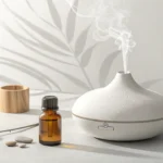 A serene flat lay image featuring a ceramic essential oil diffuser, an amber bottle, and lavender sp...